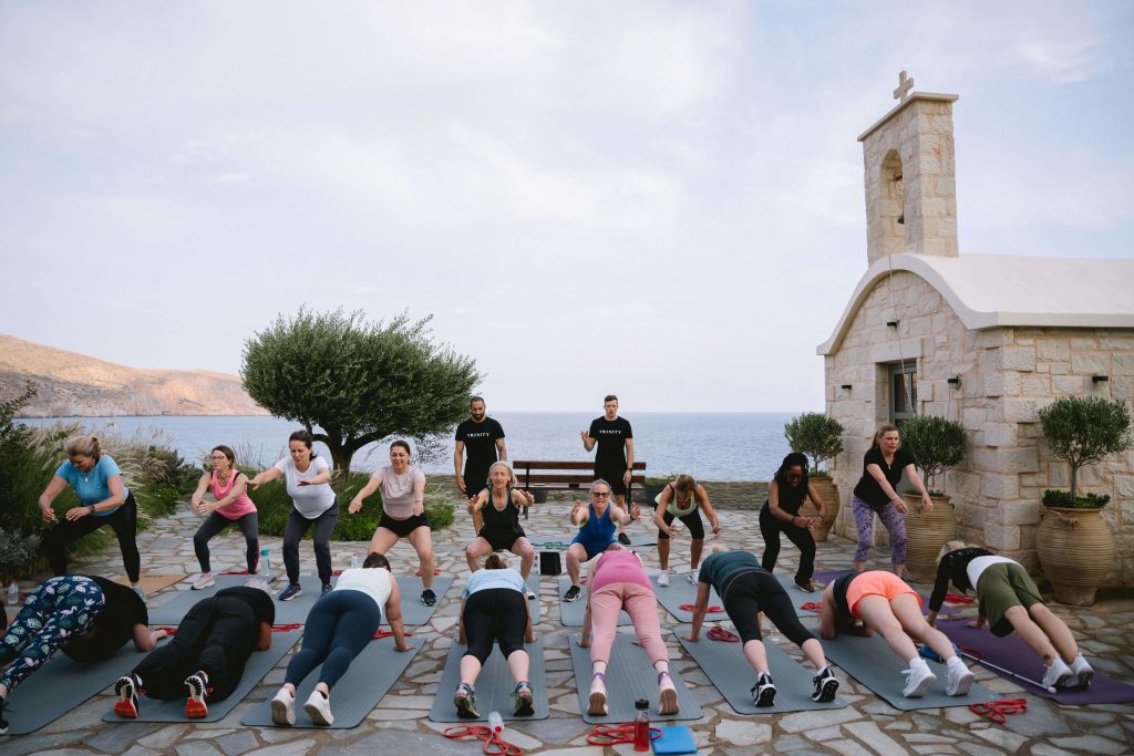 Group strength training, performing a mix of push-ups and resistance band training.
