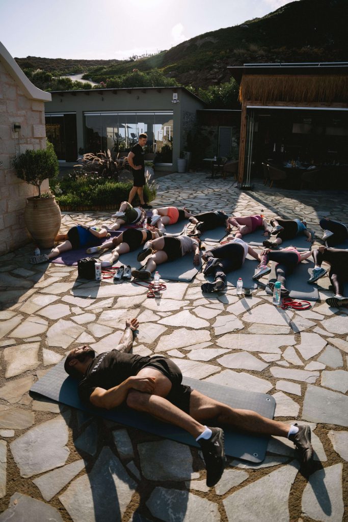 Exercises to avoid during menopause. A group coaching session on yoga mats practicing stretching.