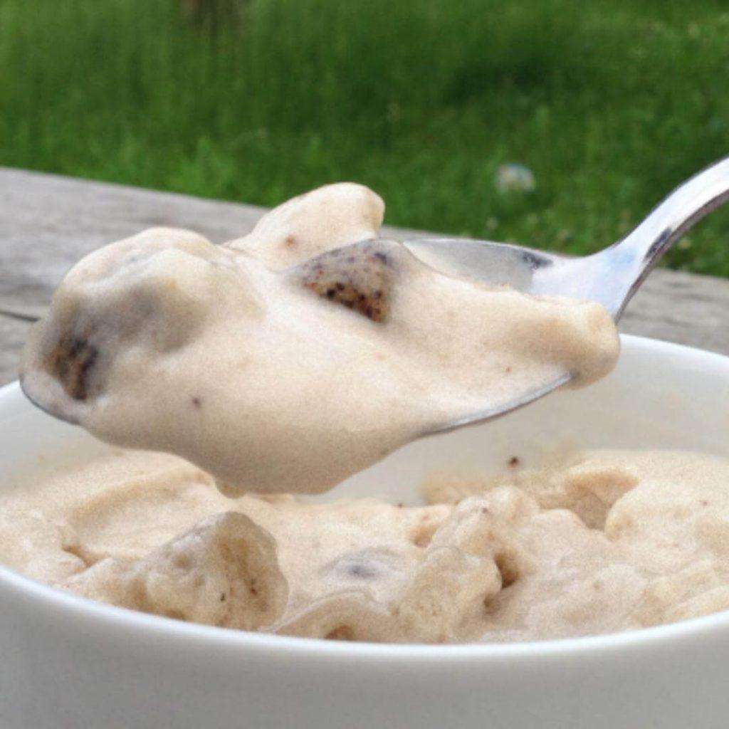 Healthy snack recipe: A spoon of cookie dough protein ice-cream above a bowl. 